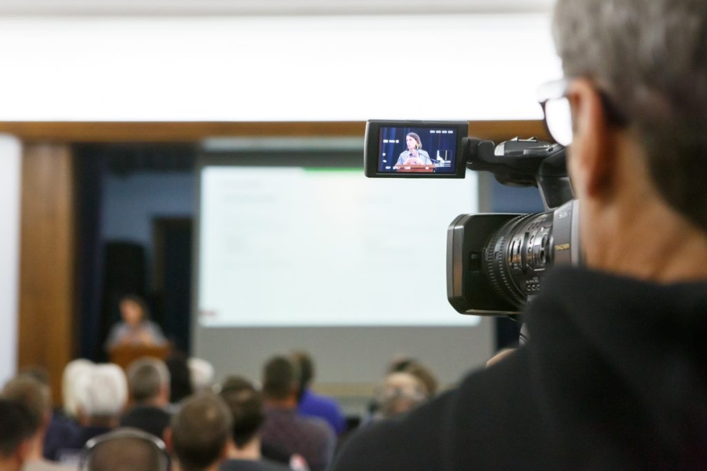 Video camera operator framing the speaker